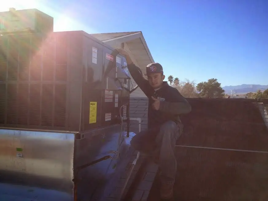 HVAC technician performing Air Duct Repair on a rooftop unit in Morris